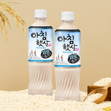Deux bouteilles de boisson au riz Morning Rice Zero Sugar posées sur un lit de grains de riz blanc avec des épis de riz en arrière-plan.