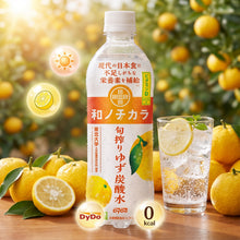 Eau gazeuse japonaise DyDo Yuzu 0 kcal, servie avec glaçons dans un verger ensoleillé.