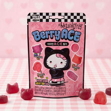Emballage Seoju Hello Kitty Berry Ace posé sur une table à carreaux roses, entouré de bonbons gélifiés aux fruits de couleur rouge et violette.