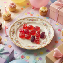 Bonbons gélifiés Seoju Hello Kitty Berry Ace présentés sur une assiette à motifs floraux avec des cupcakes sur une table décorée pour une fête.
