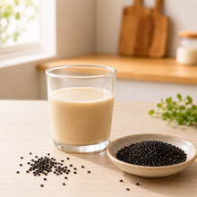 Graines de sésame noir et verre de boisson au soja sur la table
