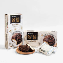Gros plan sur un gâteau Moncher Lotte coupé en deux, révélant une crème blanche et fondante entre deux biscuits moelleux au cacao.